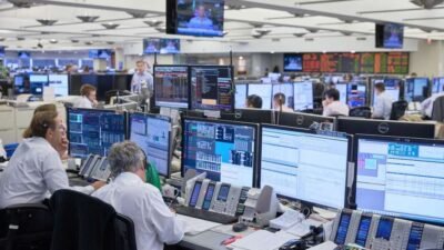 Institutional trading floor with multiple screens showing financial markets and forex activity